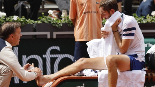 Russia's Daniil Medvedev receives medical attention during his fourth round match of the French Open tennis tournament against Australia's Alex De Minaur at the Roland Garros stadium in Paris, Monday, June 3, 2024. (AP Photo/Jean-Francois Badias)