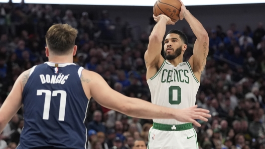 Boston Celtics forward Jayson Tatum (0) shoots against Dallas Mavericks guard Luka Doncic (77) during the second half of an NBA basketball game in Dallas, Monday, Jan. 22, 2024. (AP Photo/LM Otero)