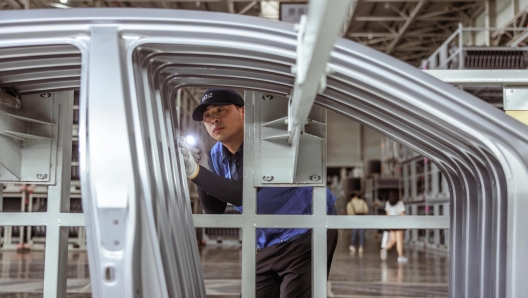 epa10195084 An employee works during an organised media tour to Dongfeng Yueda Kia Factory, in Yancheng, Jiangsu province, China, 20 September 2022. Dongfeng Yueda Kia Factory was put into production in Yancheng, in early 2014, with an annual production capacity of 450,000 vehicles per year. It has a fully automatic production line composed of stamping, welding, painting, final assembly and engine workshops.  EPA/ALEX PLAVEVSKI