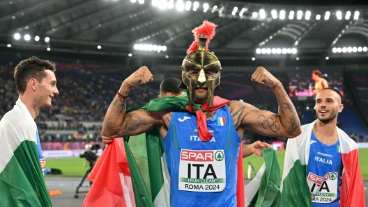 Team Italy, including Italy's athlete Lamont Marcell Jacobs, celebrate winning the men's 4 x 100m relay final during the European Athletics Championships at the Olympic stadium in Rome on June 12, 2024. (Photo by Andreas SOLARO / AFP)