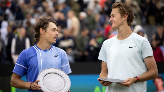 Asutralia's Alex de Minaur (L) celebrates with the trophy after winning against US' Sebastien Korda after their men's singles final match of Rosmalen Grass Court Championships tennis tournament in Rosmalen, near Hertogenbosch, on June 16, 2024. (Photo by Sander Koning / ANP / AFP) / Netherlands OUT