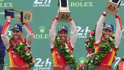 Ferrari 499P Hybrid Hypercar WEC's drivers Miguel Molina (L) of Spain, Antonio Fuoco of Italy and Nicklas Nielsen of Denmark celebrate on the podium after winning the 92nd edition of the Le Mans 24-hours endurance race in Le Mans, western France, on June 16, 2024. Ferrari won a wild and wet 92nd edition of the Le Mans 24 Hours race on June 16, 2024, as Nicklas Nielsen took the chequered flag after a vintage and gruelling race, the Dane sharing driving duties in the Italian constructor's No 50 car with Italian Antonio Fuoco and Spaniard Miguel Molina. (Photo by FRED TANNEAU / AFP)