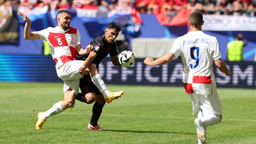 epa11422652 Qazim Laci of Albania (C) in action against Mateo Kovacic (L) and Andrej Kramaric of Croatia during the UEFA EURO 2024 group B match between Croatia and Albania in Hamburg, Germany, 19 June 2024.  EPA/ABEDIN TAHERKENAREH