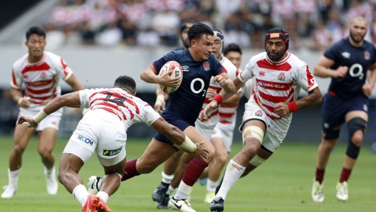 epa11429724 Marcus Smith (C) of England powers on his way to score a try against Japan during a friendly rugby match between Japan and England at the National Stadium in Tokyo, Japan, 22 June 2024.  EPA/FRANCK ROBICHON