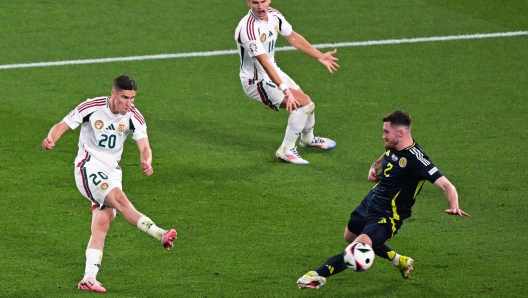 TOPSHOT - Hungary's forward #20 Roland Sallai (L) kicks the ball and fails to score against Scotland's defender #02 Anthony Ralston (R) next to Hungary's defender #11 Milos Kerkez during the UEFA Euro 2024 Group A football match between Scotland and Hungary at the Stuttgart Arena in Stuttgart on June 23, 2024. (Photo by DAMIEN MEYER / AFP)