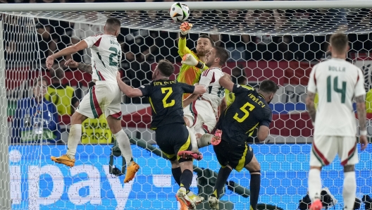 Scotland's goalkeeper Angus Gunn and Hungary's Barnabas Varga, center right, vie for the ball during a Group A match between Scotland and Hungary at the Euro 2024 soccer tournament in Stuttgart, Germany, Sunday, June 23, 2024. (AP Photo/Matthias Schrader)