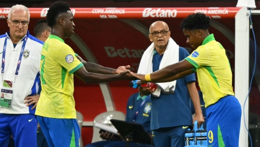 Brazil's forward #09 Endrick shakes hands with Brazil's forward #07 Vinicius Junior as he replaces him during a substitution during the Conmebol 2024 Copa America tournament group D football match between Brazil and Costa Rica at SoFi Stadium in Inglewood, California on June 24, 2024. (Photo by Patrick T. Fallon / AFP)