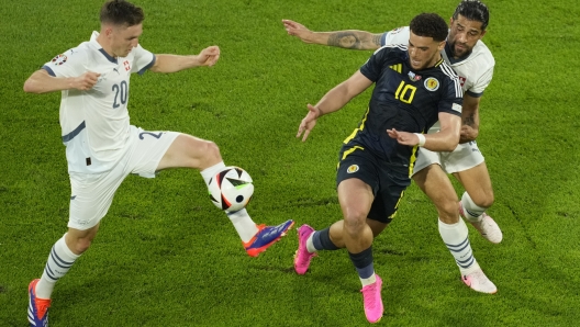 Scotland's Che Adams, right, challenges for the ball with Switzerland's Michel Aebischer, left, during a Group A match between Scotland and Switzerland at the Euro 2024 soccer tournament in Cologne, Germany, Wednesday, June 19, 2024. (AP Photo/Andreea Alexandru)