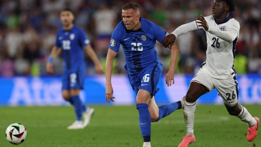 England's midfielder #26 Kobbie Mainoo (R) fights for the ball with Slovenia's midfielder #26 Josip Ilicic (L) during the UEFA Euro 2024 Group C football match between England and Slovenia at the Cologne Stadium in Cologne on June 25, 2024. (Photo by Adrian DENNIS / AFP)