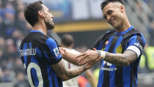 Inter Milan's Hakan Calhanoglu, left, celebrates with Inter Milan's Lautaro Martinez after scoring his side's second goal from a penalty kick during a Serie A soccer match between Inter Milan and Torino at the San Siro stadium in Milan, Italy, Sunday, April 28, 2024. (AP Photo/Luca Bruno)