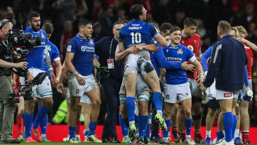 Italy's teammates celebrate after winning at the end of the Six Nations international rugby union match between Wales and Italy at the Principality Stadium in Cardiff, south Wales, on March 16, 2024. Italy won 24 - 21 against Wales. (Photo by Geoff Caddick / AFP) / RESTRICTED TO EDITORIAL USE. Use in books subject to Welsh Rugby Union (WRU) approval.