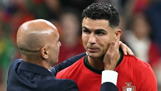 Portugal's forward #07 Cristiano Ronaldo (R) celebrates with Portugal's head coach Roberto Martinez after winning the UEFA Euro 2024 round of 16 football match between Portugal and Slovenia at the Frankfurt Arena in Frankfurt am Main on July 1, 2024. (Photo by PATRICIA DE MELO MOREIRA / AFP)