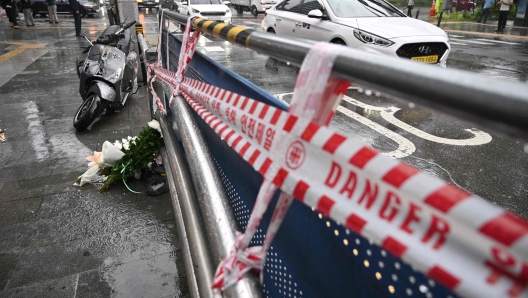 Flowers (bottom L) are placed at the site of a car accident, which left at least nine people dead, in Seoul on July 2, 2024. At least nine people were killed and four others were injured when a car struck pedestrians near Seoul city hall on July 1, police said. (Photo by Jung Yeon-je / AFP)