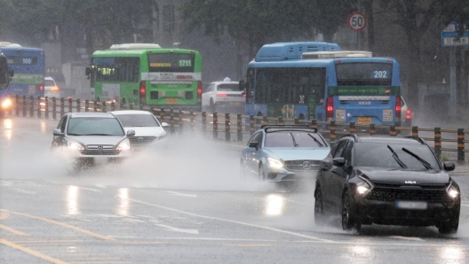 epa11451695 Cars create sprays of water in Seoul, South Korea, 02 July 2024, amid heavy rain nationwide.  EPA/YONHAP SOUTH KOREA OUT