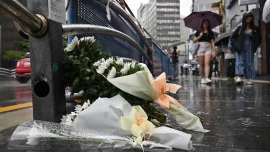 Flowers are seen placed at the site of a car accident, which left at least nine people dead, in Seoul on July 2, 2024. At least nine people were killed and four others were injured when a car struck pedestrians near Seoul city hall on July 1, police said. (Photo by Jung Yeon-je / AFP)