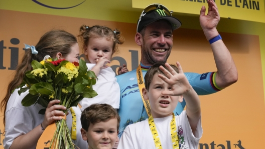 Britain's sprinter Mark Cavendish celebrates on the podium with his wife and children after winning a record 35th Tour de France stage to break the record of Belgian legend Eddy Merckx in the fifth stage of the Tour de France cycling race over 177.4 kilometers (110.2 miles) with start in Saint-Jean-de-Maurienne and finish in Saint-Vulbas, France, Wednesday, July 3, 2024. (AP Photo/Jerome Delay)