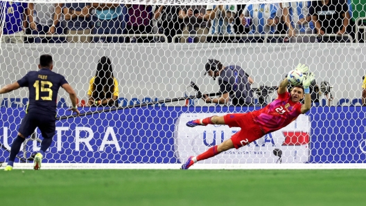 Argentina's goalkeeper #23 Emiliano Martinez saves a goal from the penalty spot from Ecuador's midfielder #15 Angel Mena in a penalty shoot out during the Conmebol 2024 Copa America tournament quarter-final football match between Argentina and Ecuador at NRG Stadium in Houston, Texas, on July 4, 2024. (Photo by CHARLY TRIBALLEAU / AFP)