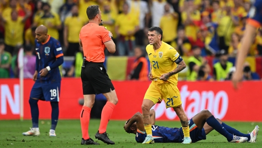 MUNICH, GERMANY - JULY 02: Nicolae Stanciu of Romania reacts before he is shown a yellow card by Referee Felix Zwayer during the UEFA EURO 2024 round of 16 match between Romania and Netherlands at Munich Football Arena on July 02, 2024 in Munich, Germany. (Photo by Clive Mason/Getty Images)