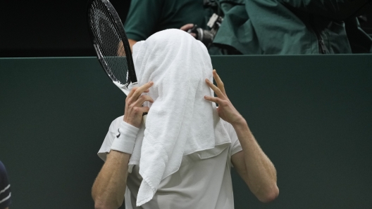 Jannik Sinner of Italy covers his face with a towel during his quarterfinal against Daniil Medvedev of Russia at the Wimbledon tennis championships in London, Tuesday, July 9, 2024. (AP Photo/Alberto Pezzali)