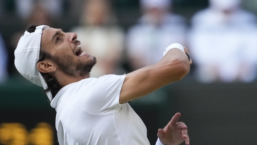 Lorenzo Musetti of Italy celebrates after defeating Taylor Fritz of the United States in their quarterfinal match at the Wimbledon tennis championships in London, Wednesday, July 10, 2024. (AP Photo/Mosa'ab Elshamy)