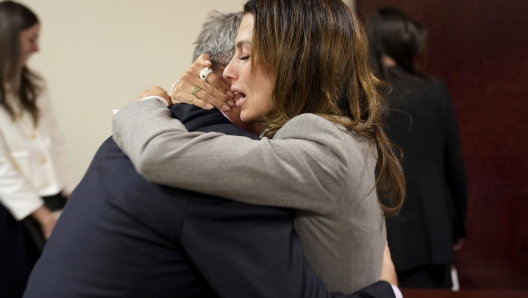 Actor Alec Baldwin, left, and his wife Hilaria embrace after a judge threw out the involuntary manslaughter case for the 2021 fatal shooting of cinematographer Halyna Hutchins during filming of the Western movie "Rust," Friday, July 12, 2024, in Santa Fe, N.M. (Ramsay de Give/Pool Photo via AP)