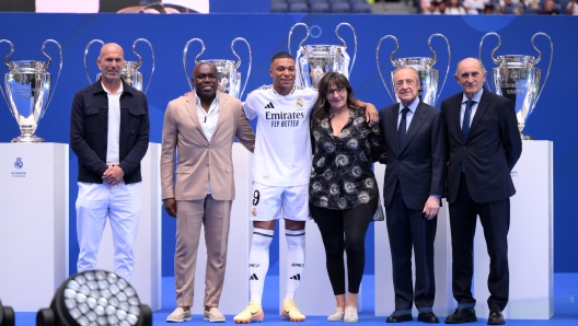 MADRID, SPAIN - JULY 16: Real Madrid new signing, Kylian Mbappe (3L) poses for a photo with former Real Madrid player and coach, Zinedine Zidane (L), former Real Madrid player, Pirri (R) and President of Real Madrid, Florentino Perez Rodriguez (2R) and his parents, father, Wilfried Mbappe (2L) and mother, Fayza Lamari (3R) as he is unveiled at Estadio Santiago Bernabeu on July 16, 2024 in Madrid, Spain. (Photo by David Ramos/Getty Images)