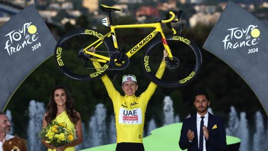 UAE Team Emirates team's Slovenian rider Tadej Pogacar celebrates his overall victory on the podium with the overall leader's yellow jersey after the 21st and final stage of the 111th edition of the Tour de France cycling race, a 33,7 km individual time-trial between Monaco and Nice, on July 21, 2024. (Photo by Anne-Christine POUJOULAT / AFP)