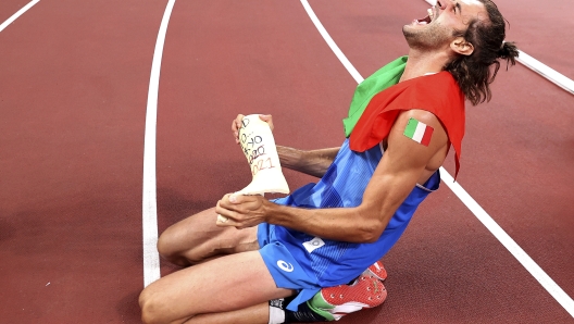 Gold medalist Gianmarco Tamberi of Italy celebrates on the track after jointly winning the final of the men's high jump at the 2020 Summer Olympics, Sunday, Aug. 1, 2021, in Tokyo, Japan. (Cameron Spencer/Pool Photo via AP)