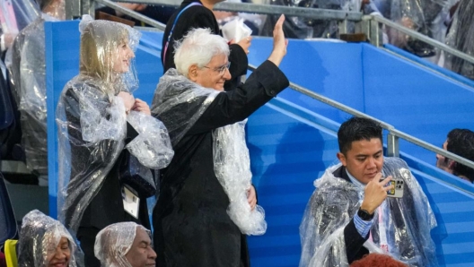 Il Presidente della Repubblica, Sergio Mattarella, presente sugli spalti di Trocadero per la cerimonia di apertura dei Giochi Olimpici, si è alzato in piedi per salutare l'imbarcazione dell'Italia guidata dai due portabandiera, Gianmarco Tamberi e Arianna Errigo. Il Capo dello Stato sta assistendo alla cerimonia nonostante la pioggia incessante che lo ha costretto a indossare un poncho, Parigi, 26 luglio 2024./// Italian President Sergio Mattarella present in the stands of Trocadero for the opening ceremony of the Olympic Games, stood up to greet the Italian boat led by the two Italian flag bearers, Gianmarco Tamberi and Arianna Errigo. Mattarella is attending the ceremony despite the incessant rain that forced him to wear a poncho, in Paris, France, 26 July 2024. ANSA/ STRINGER