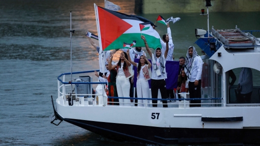 Athletes from the Palestine delegation sail in a boat along the river Seine during the opening ceremony of the Paris 2024 Olympic Games in Paris on July 26, 2024. (Photo by Luis TATO / AFP)