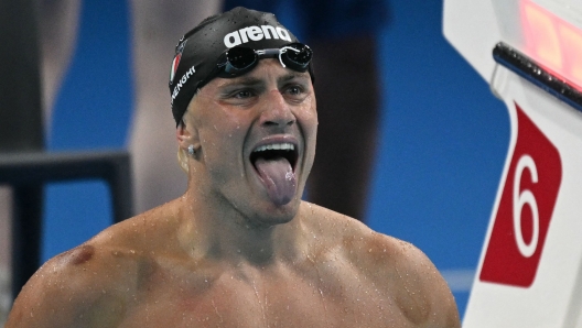 Italy's Nicolo Martinenghi celebrates after winning the final of the men's 100m breaststroke swimming event during the Paris 2024 Olympic Games at the Paris La Defense Arena in Nanterre, west of Paris, on July 28, 2024. (Photo by Oli SCARFF / AFP)