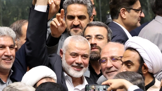 epa11510676 Hamas political leader Ismail Haniyeh (C) flashes victory sign as surrounded by Iranian lawmakers at the Iranian parliament in Tehran, Iran, 30 July 2024 (issued 31 July 2024). According to an Iranian Revolutionary Guard Corps (IRGC) statement on 31 July 2024, Haniyeh and one of his bodyguards were targeted and killed in Tehran on 31 July 2024.  EPA/ABEDIN TAHERKENAREH