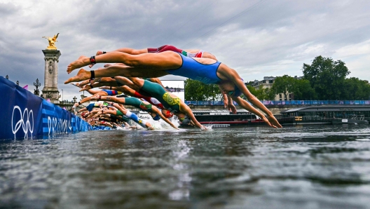 (FILES) Athletes compete in the swimming race in the Seine during the women's individual triathlon at the Paris 2024 Olympic Games in central Paris on July 31, 2024. Paris Olympics organisers have cancelled training for triathletes in the River Seine again because of poor water quality, leading to more uncertainty over whether the mixed relay will go ahead as planned on August 5, 2024. (Photo by MARTIN BUREAU / POOL / AFP)