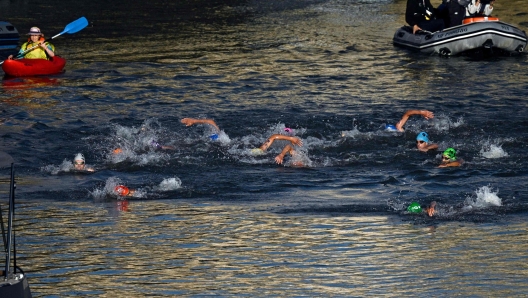 Athletes compete in the swimming race in the Seine, during the mixed's relay triathlon, at the Paris 2024 Olympic Games, in central Paris, on August 5, 2024. (Photo by JULIEN DE ROSA / AFP)