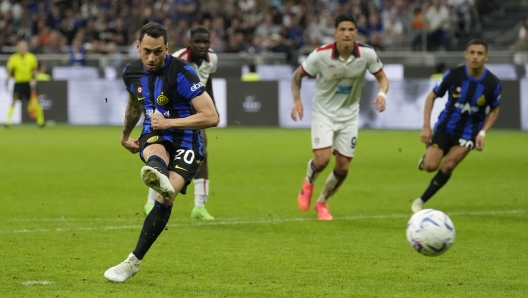 Inter Milan's Hakan Calhanoglu scores his side's second goal from a penalty kick during the Italian Serie A soccer match between Inter Milan and Cagliari at the San Siro stadium in Milan, Italy, Sunday, April 14, 2024. (AP Photo/Antonio Calanni)