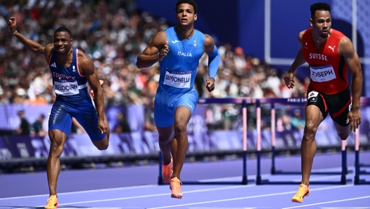 France's Wilhem Belocian, Italy's Lorenzo Ndele Simonelli and Switzerland's Jason Joseph cross the finish line in the men's 110m hurdles heat of the athletics event at the Paris 2024 Olympic Games at Stade de France in Saint-Denis, north of Paris, on August 4, 2024. (Photo by Jewel SAMAD / AFP)