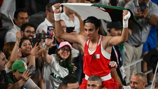 Algeria's Imane Khelif reacts after beating China's Yang Liu (Blue) in the women's 66kg final boxing match during the Paris 2024 Olympic Games at the Roland-Garros Stadium, in Paris on August 9, 2024. (Photo by Mauro PIMENTEL / AFP)