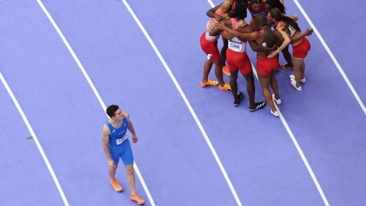 PARIS, FRANCE - AUGUST 09: Filippo Tortu of Team Italy walks past Athletes of Team Canada after competing in the Men's 4x100m Relay Final on day fourteen of the Olympic Games Paris 2024 at Stade de France on August 09, 2024 in Paris, France. (Photo by Richard Heathcote/Getty Images)