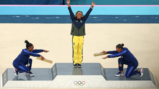 PARIS, FRANCE - AUGUST 05: Gold medalist Rebeca Andrade (C) of Team Brazil, silver medalist Simone Biles (L) of Team United States and bronze medalist Jordan Chiles (R) of Team United States celebrate on the podium at the Artistic Gymnastics Women's Floor Exercise Medal Ceremony on day ten of the Olympic Games Paris 2024 at Bercy Arena on August 05, 2024 in Paris, France. (Photo by Elsa/Getty Images) *** BESTPIX ***