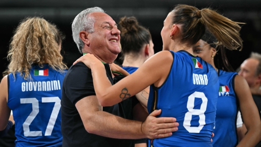 Italy's #08 Alessia Orro celebrates with Italy's head coach Julio Velasco celebrate after winning the women's volleyball gold medal match between USA and Italy at the South Paris Arena 1 in Paris during the Paris 2024 Olympic Games on August 11, 2024. (Photo by Patricia DE MELO MOREIRA / AFP)