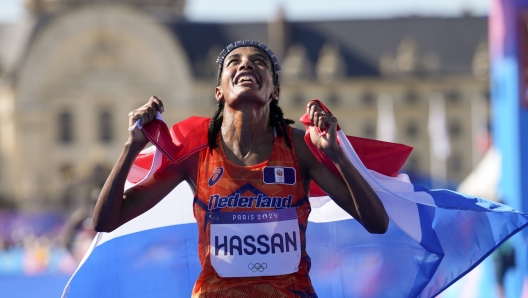 Sifan Hassan, of the Netherlands, celebrates after crossing the finish line to win the gold medal at the end of the women's marathon competition at the 2024 Summer Olympics, Sunday, Aug. 11, 2024, in Paris, France. (AP Photo/Vadim Ghirda)