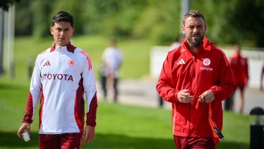 BURTON UPON TRENT, ENGLAND - AUGUST 09: AS Roma coach Daniele De Rossi with Paulo Dybala during the training session at St George's Park on August 09, 2024 in Burton upon Trent, England.  (Photo by Fabio Rossi/AS Roma via Getty Images)