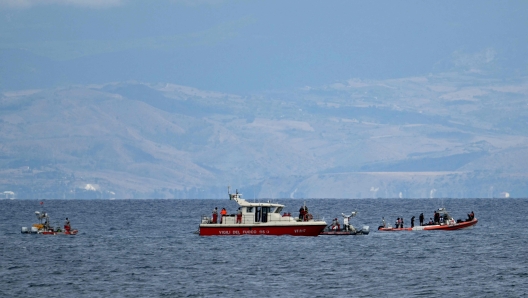 Rescue boats of the Vigili del Fuoco, the Italian Corps. of Firefighters operate off Porticello near Palermo, on August 21, 2024 two days after the British-flagged luxury yacht Bayesian sank. Rescuers with divers and an underwater drone search for six people believed trapped when the boat sank. Among the six missing were UK tech entrepreneur Mike Lynch and his 18-year-old daughter Hannah, and Jonathan Bloomer, the chair of Morgan Stanley International, and his wife Judy. The Bayesian, which had 22 people aboard including 10 crew, was anchored some 700 metres from port before dawn when it was struck by a waterspout, a sort of mini tornado. Fifteen people aboard, including a mother with a one-year-old baby, were plucked to safety; one man has been found dead; and six people remain missing. (Photo by Alberto PIZZOLI / AFP)