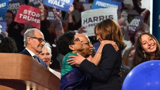 US Vice President and 2024 Democratic presidential candidate Kamala Harris (C-R) greets relatives on the fourth and last day of the Democratic National Convention (DNC) at the United Center in Chicago, Illinois, on August 22, 2024. Kamala Harris accepted the Democratic presidential nomination in Chicago on August 22, before a rapturous crowd, pledging a "new way forward" and warning that Donald Trump will take America backward if he wins November's blockbuster election. (Photo by ANDREW CABALLERO-REYNOLDS / AFP)