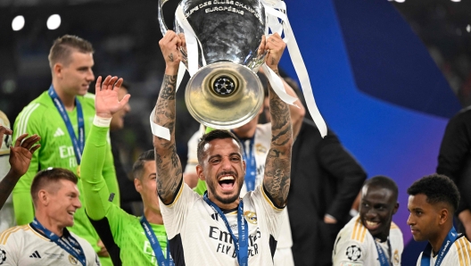 (FILES) Real Madrid's Spanish forward #14 Joselu holds the trophy as he celebrates the victory at the end of the UEFA Champions League final football match between Borussia Dortmund and Real Madrid, at Wembley stadium, in London, on June 1, 2024. Spanish international forward Joselu leaves Real Madrid to join the Qatari club Al-Gharafa, the Real Madrid CF announced on June 28, 2024. (Photo by INA FASSBENDER / AFP)