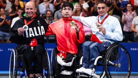 (L/R) Silver medalist Italy's Efrem Morelli, gold medalist Japan's Takayuki Suzuki and bronze medalist Spain's Miguel Luque celebrate on the podium of the men's S2 50m SB3 breaststroke swimming event during the Paris 2024 Paralympic Games at The Paris La Defense Arena in Nanterre, west of Paris on August 29, 2024. (Photo by Franck FIFE / AFP)