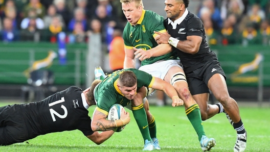 New Zealand's centre Jordie Barrett (L) tackles South Africa's hooker Malcolm Marx (2nd L) during the Rugby Championship Test match between South Africa and New Zealand at the Cape Town Stadium in Cape Town on September 7, 2024. (Photo by Rodger Bosch / AFP)