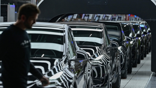 (FILES) A line of electric vehicles of the model Y is pictured during the start of the production at Tesla's "Gigafactory" plant on March 22, 2022 in Gruenheide, southeast of Berlin. Tesla halted production at its German factory on March 5, 2024 after assailants allegedly set fire to high-voltage lines nearby, cutting power to the US electric carmaker's only plant in Europe, the company and authorities said. (Photo by Patrick Pleul / POOL / AFP)