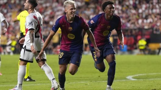 Barcelona's Dani Olmo, centre, celebrates after scoring his side's second goal during the Spanish La Liga soccer match between Rayo Vallecano and Barcelona at the Vallecas stadium in Madrid, Spain, Tuesday, Aug. 27, 2024. (AP Photo/Manu Fernandez)