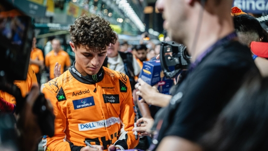 epa11613925 British driver Lando Norris of McLaren F1 Team sign autographs in the pitlane ahead of the Singapore Formula One Grand Prix at the Marina Bay Street Circuit, Singapore, 19 September 2024. The Singapore Formula One Grand Prix takes place on 22 September 2024.  EPA/TOM WHITE